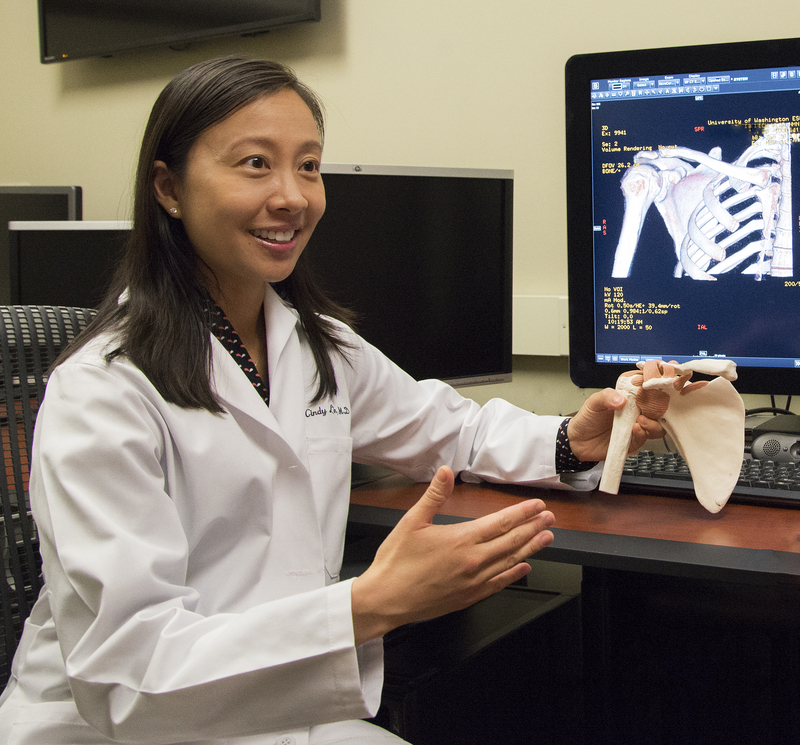 Dr Cindy Lin holds a model of a hip bone. 