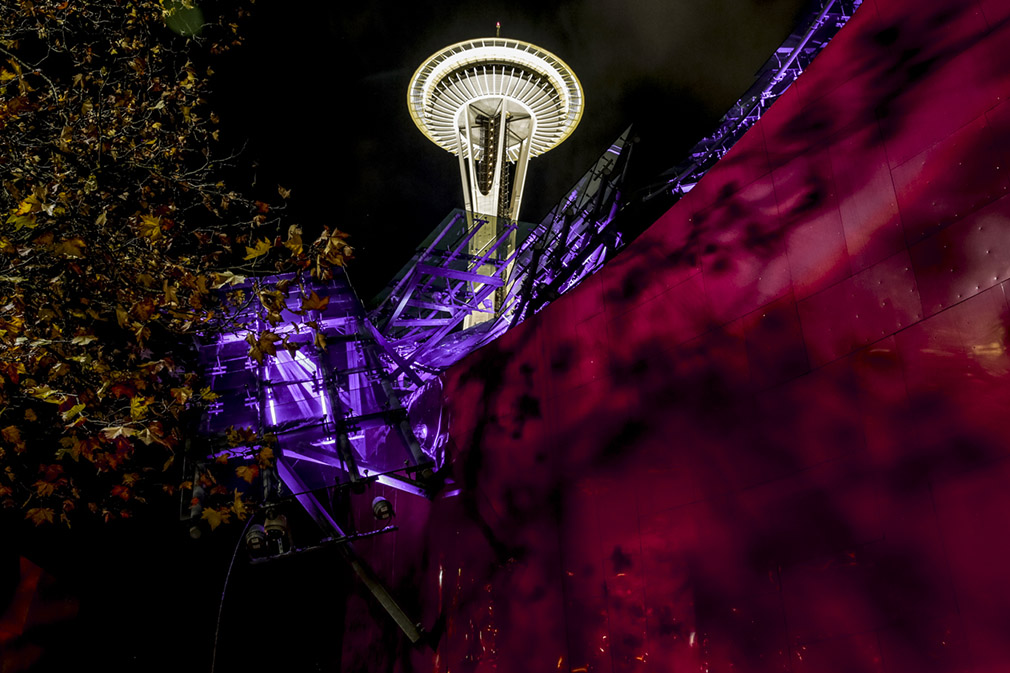 A night shot, looking up at the Space Needle lit up in Husky purple. 