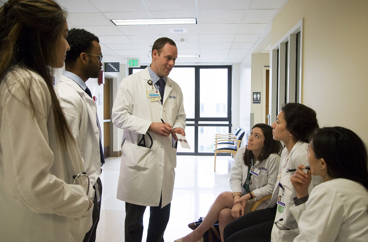 A doctor speaks to a group of students.