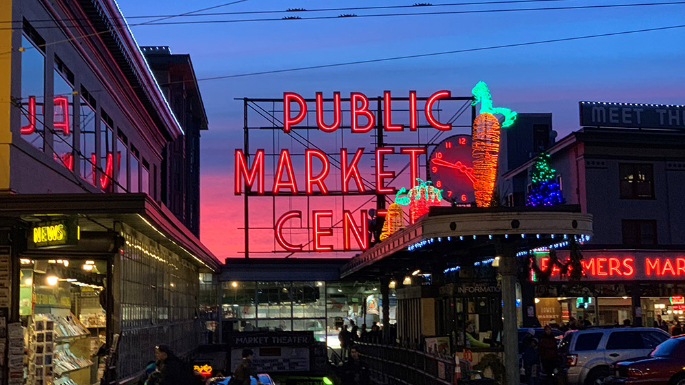 The neon Pike Place Market sign at dusk. 
