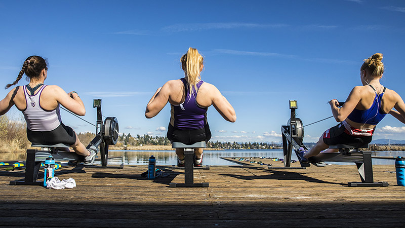 Members of the UW women's rowing team work on rowing machines near Lake Washington.