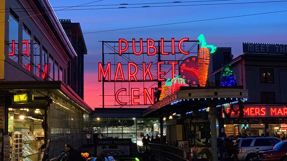 The neon Pike Place Market sign at dusk.